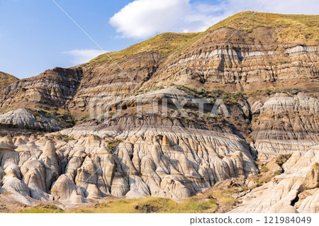 Canyon in badlands with eroded formations on the hills in summer. 121984049