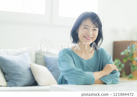 Middle-aged woman in the living room 121984472