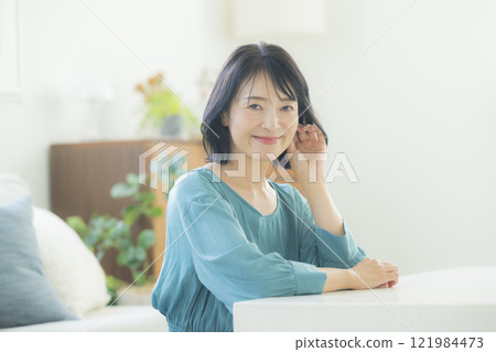 Middle-aged woman in the living room 121984473