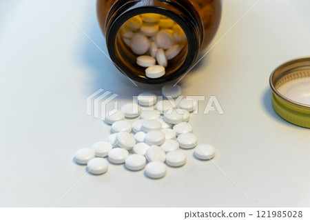 White pills spilled on the table 121985028