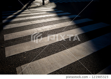 A crosswalk illuminated by low sunlight a-1 121985323