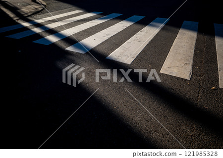 A crosswalk illuminated by low sunlight b-1 A crosswalk illuminated by low sunlight b-1 121985328