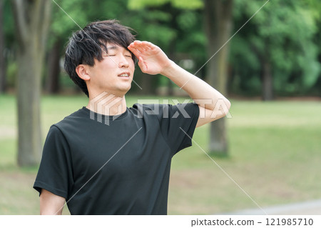 Asian man in sportswear suffering from headache/migraine while running/walking 121985710