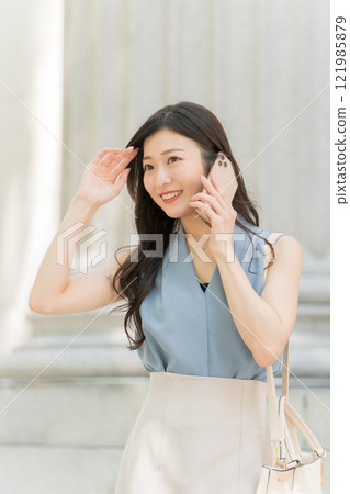 A businesswoman calling on her smartphone in an office district A businesswoman calling on her smartphone in an office district 121985879