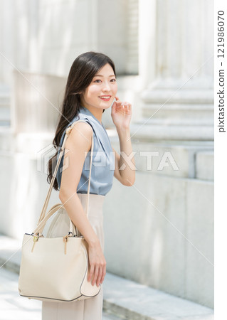 Business woman walking with a shoulder bag Business woman walking with a shoulder bag 121986070