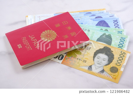 Korean currency, won (KRW) banknotes and a passport (10-year general passport, red), giving an image of a trip to Korea 121986482