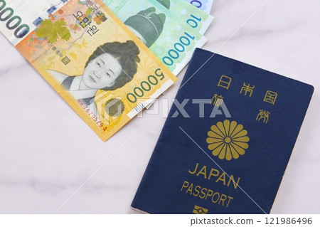 Korean currency, won (KRW) banknotes and a passport (5-year general passport, navy blue), giving an image of a trip to Korea 121986496