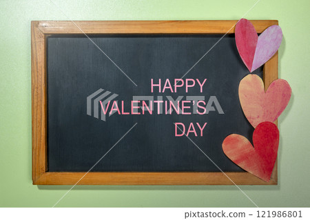 Red hearts on the chalkboard with text of Happy Valentine Day on a colored background 121986801