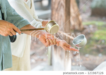 Hands of a man and woman purifying themselves at the temizuya Hands of a man and woman purifying themselves at the temizuya 121987126
