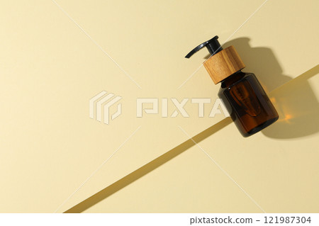 Cosmetic oil in a brown bottle on a light background 121987304