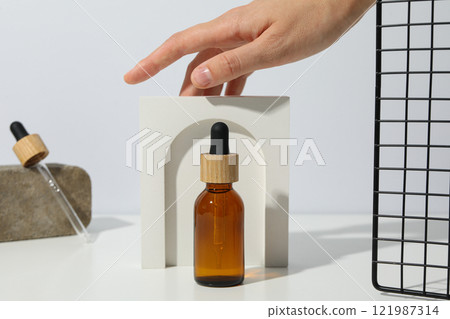 Cosmetic oil in a brown bottle with a decorative bow 121987314
