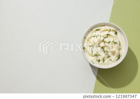 Philadelphia cheese in a ceramic plate on a green background. Philadelphia cheese in a ceramic plate on a green background. 121987347