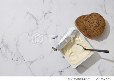 Philadelphia cheese in a plastic container, on a white background. Philadelphia cheese in a plastic container, on a white background. 121987360