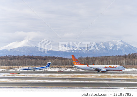Planes at New Chitose Airport in winter, Mount Tarumae and Mount Fusubushi, Chitose, Hokkaido 121987923