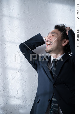 A man in a suit holding his head and feeling shocked because of job hunting, changing jobs, work mistakes and personnel issues A man in a suit holding his head and feeling shocked because of job hunting, changing jobs, work mistakes and personnel issues 121988043