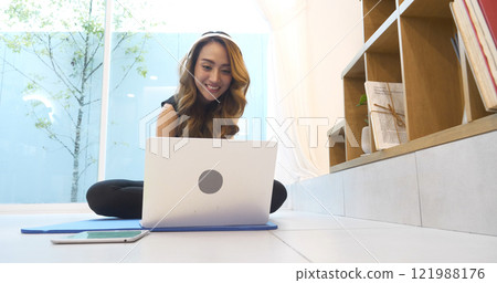 Happy asian woman video call web conference sitting on cozy sofa in living room at home. Smile Female asian people use laptop notebook computer headphones online call working from home watching video Happy asian woman video call web conference sitting on cozy sofa in living room at home. Smile Female asian people use laptop notebook computer headphones online call working from home watching video 121988176