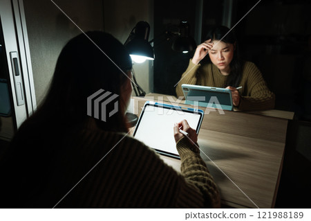 stressed woman working with digital tablet with white blank screen at night 121988189