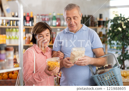 Couple elderly man and woman choosing flakes in grocery store 121988605
