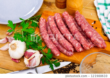 Catalan raw pork sausage longaniza ready for grilling on wooden board 121988610