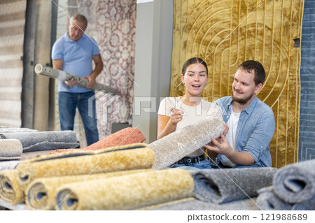 Husband and wife choose soft carpet together to create coziness in their home Husband and wife choose soft carpet together to create coziness in their home 121988689