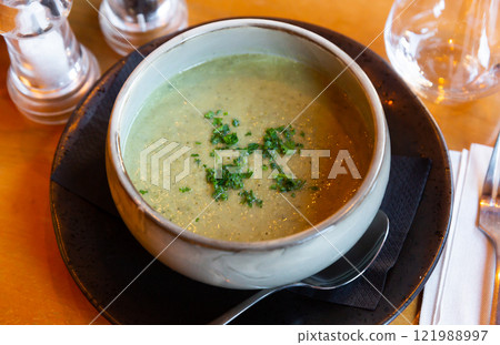 Healthy vegetable puree soup served with chopped fresh greens 121988997