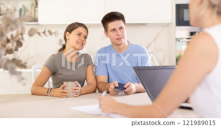 Married couple clients listen attentively and intently to woman of seller 121989015