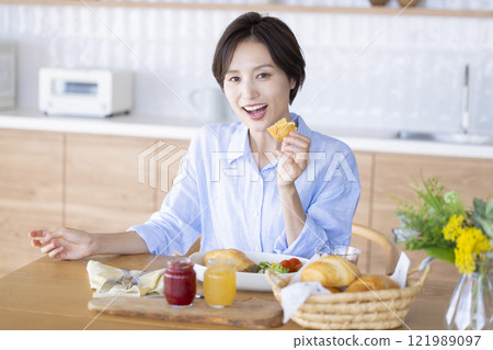 A woman eating breakfast  A woman eating breakfast  121989097