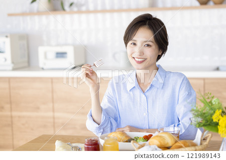 A woman eating breakfast A woman eating breakfast 121989143