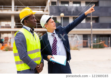 Two architect, civil engineer or building contractor colleagues on construction site 121989165