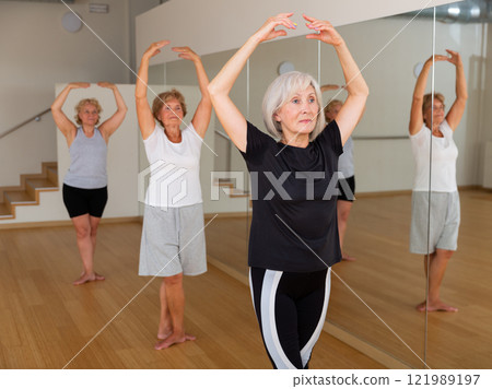 Senior women in sportswear dancing ballet inside gym 121989197