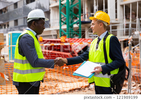 Architect and engineer construction workers shaking hands while working for teamwork and cooperation concept after finish an agreement in construction site Architect and engineer construction workers shaking hands while working for teamwork and cooperation concept after finish an agreement in construction site 121989199