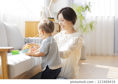 Boy and mom playing in the living room 121989419