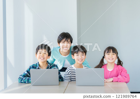 Elementary school student operating a computer in the classroom 121989764