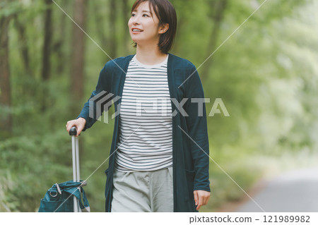 Tourists rolling suitcases down mountain roads 121989982