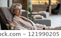 A serene moment of relaxation in a modern spa. This woman enjoys the tranquility of her surroundings while dressed in a cozy robe. Ideal for wellness and self-care themes. AI 121990205