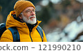 An elderly man enjoys a moment outdoors while wearing a vibrant yellow jacket and beanie. He gazes thoughtfully into the distance. Perfect for travel and lifestyle themes. AI 121990210