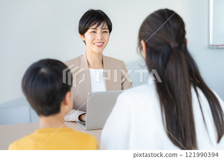 Parents and children having an interview with a teacher 121990394