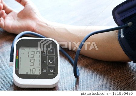 Man check blood pressure monitor and heart rate monitor with digital pressure gauge. Health care and Medical concept Man check blood pressure monitor and heart rate monitor with digital pressure gauge. Health care and Medical concept 121990450