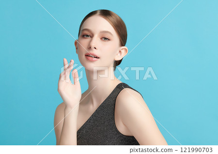 Beautiful young woman with clean fresh skin on blue background, Face care, Facial treatment, Cosmetology, beauty and spa, women portrait. 121990703