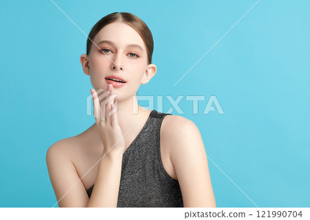 Beautiful young woman with clean fresh skin on blue background, Face care, Facial treatment, Cosmetology, beauty and spa, women portrait. 121990704