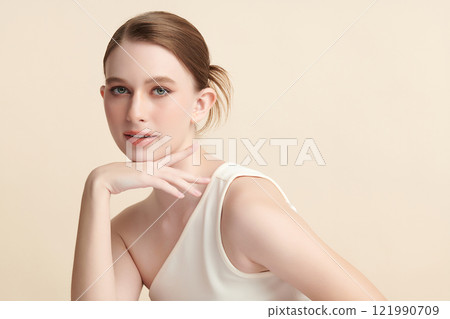 Beautiful young woman with clean fresh skin on beige background, Face care, Facial treatment, Cosmetology, beauty and spa, women portrait. 121990709