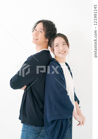 Young man and woman smiling back to back 121991145