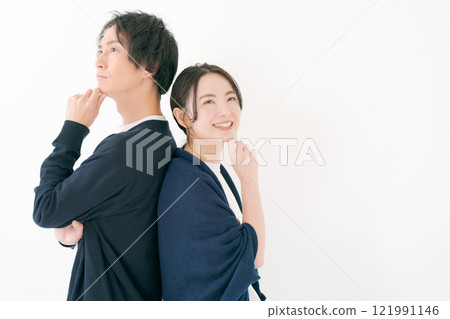 Young man and woman smiling back to back 121991146