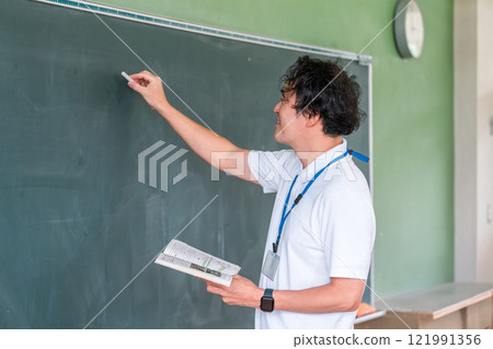 Male teacher giving a lesson in front of the blackboard 121991356