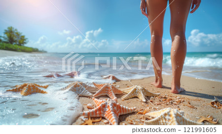 Woman walking along beach with starfish and seashells 121991605