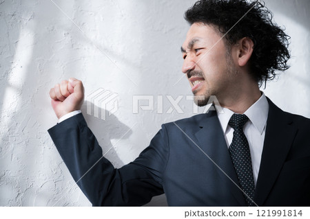 男子沮喪地敲打牆壁 男子沮喪地敲打牆壁 121991814