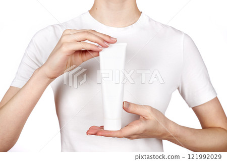 Young girl holding a tube of cream Young girl holding a tube of cream 121992029