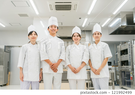 Chefs and cooks in chef coats standing in the kitchen 121992499