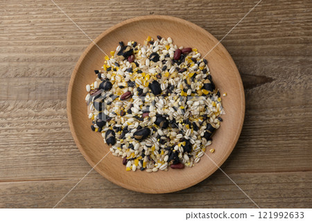 木紋背景下木盤上十六粒稻米的俯視圖 121992633