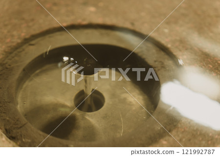 Close-up of a drain with water flowing through it Close-up of a drain with water flowing through it 121992787